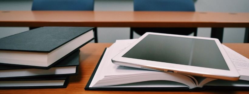 Tablet Resting on Book on a Table Desk