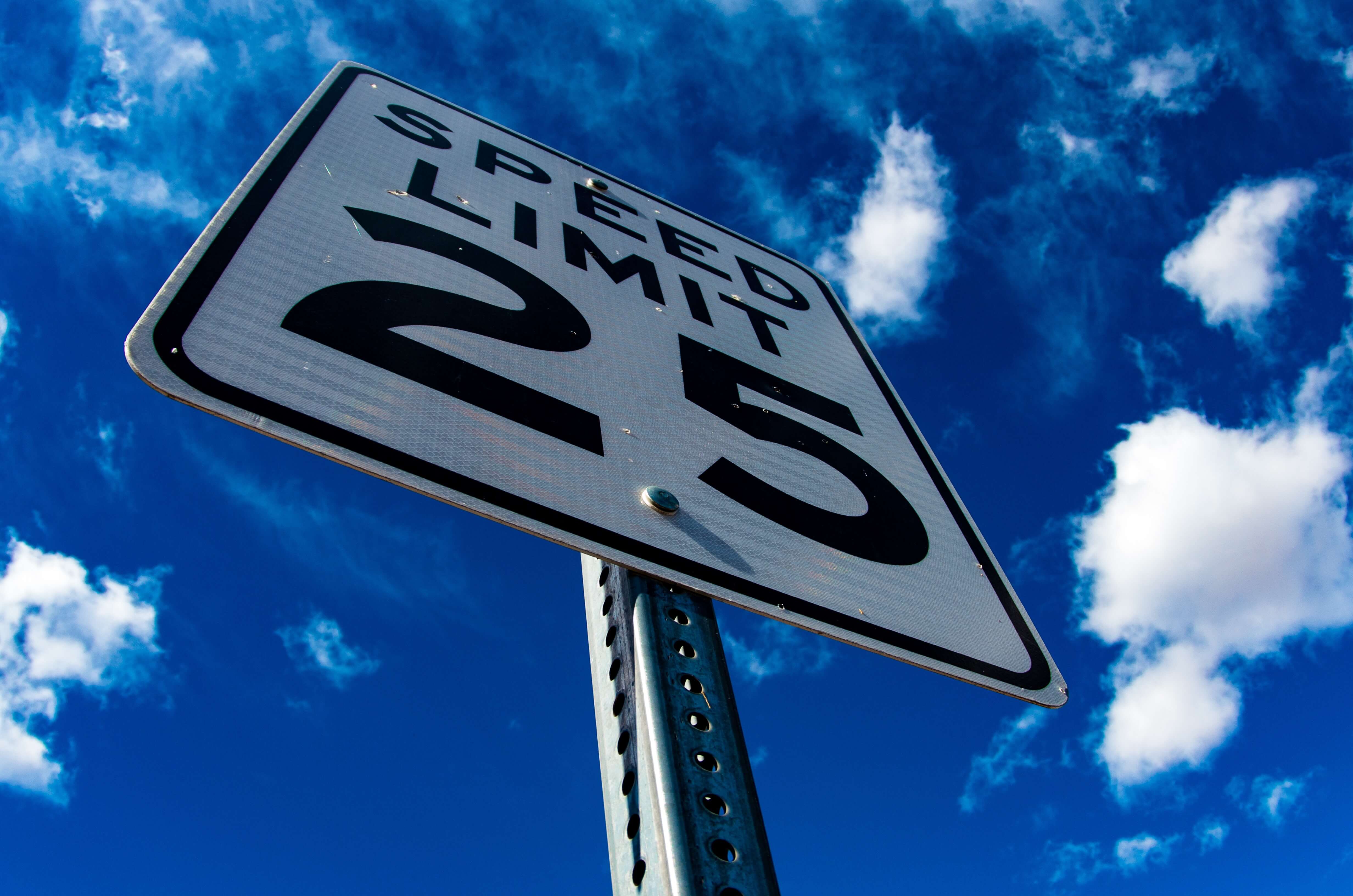 25 Miles Per Hour Speed Limit Sign Set Against Blue Sky