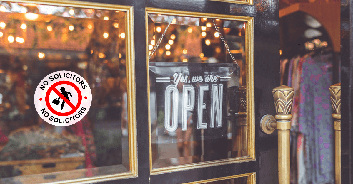 Store Front with a Glass Pane Door, a "We're Open Sign" Hangs on the Inside