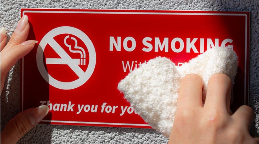 A plastic sign being cleaned with a towel